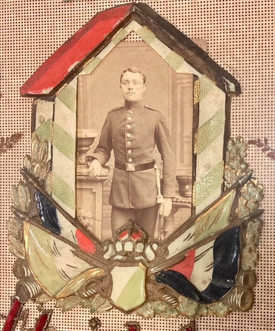 Close-up of soldier standing inside a sentry box with a red roof and faded green and white stripes.