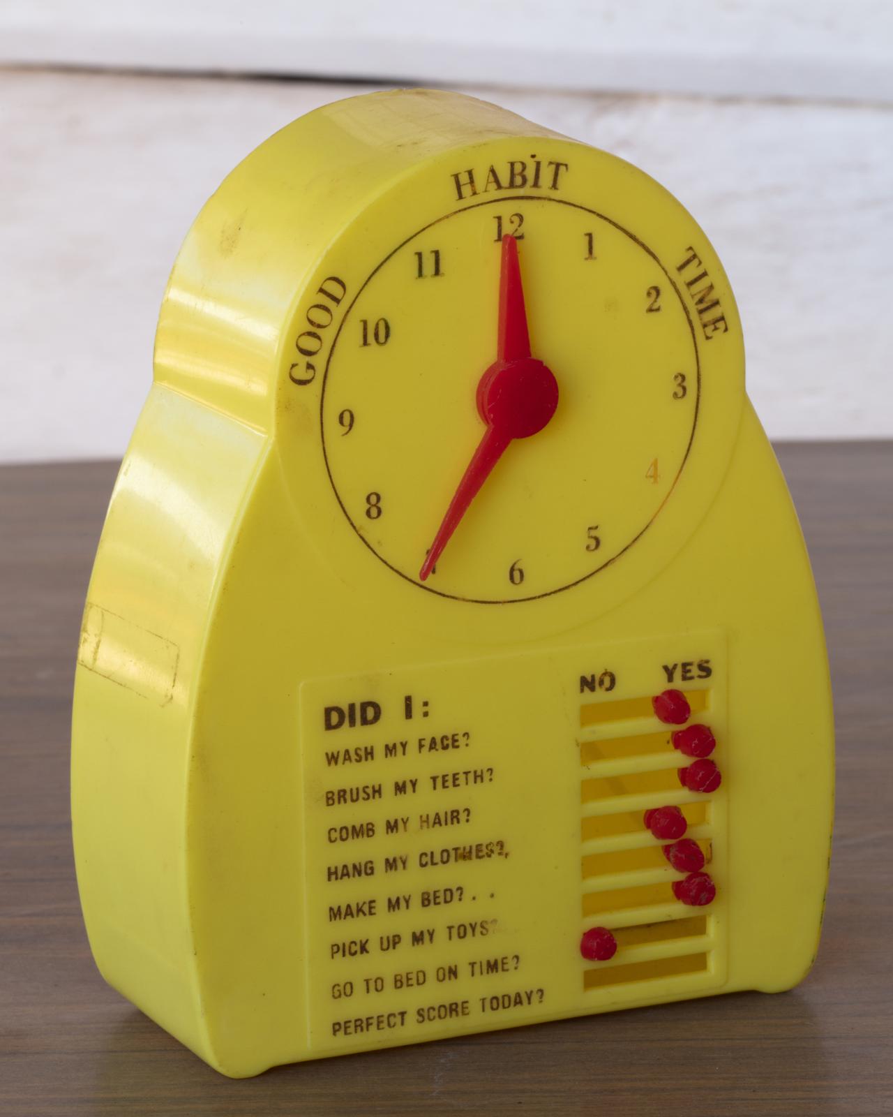 yellow and red toy clock with 'good habit time' on it, and habit 'no/yes' sliders below