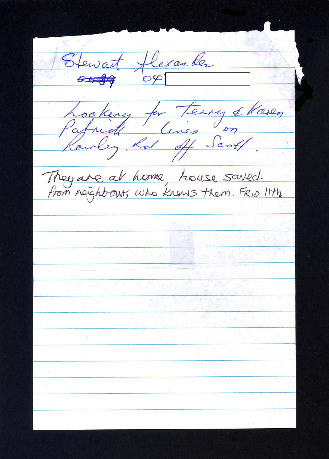 White piece of blue lined note paper, torn from book with seven lines of blue and black hand written text