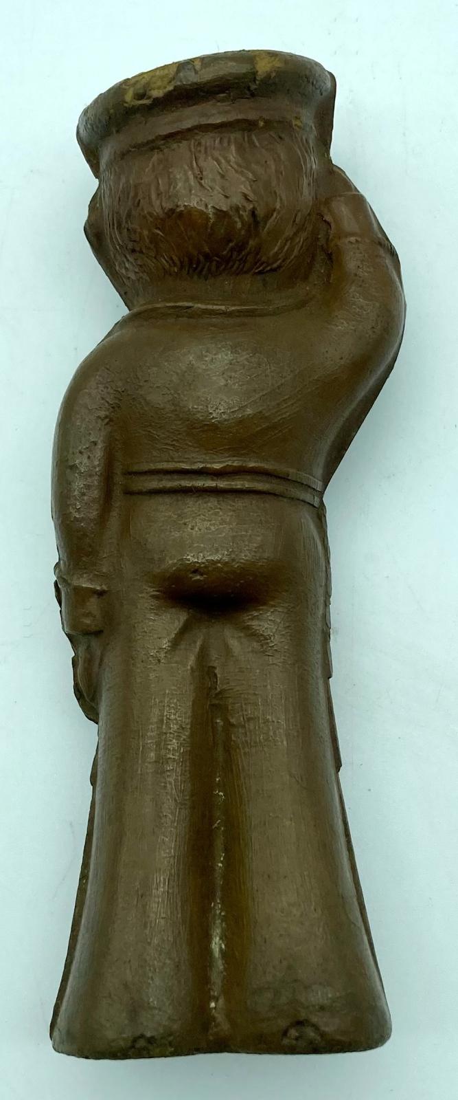 Reverse of lacquered, brown rubber sailor doll