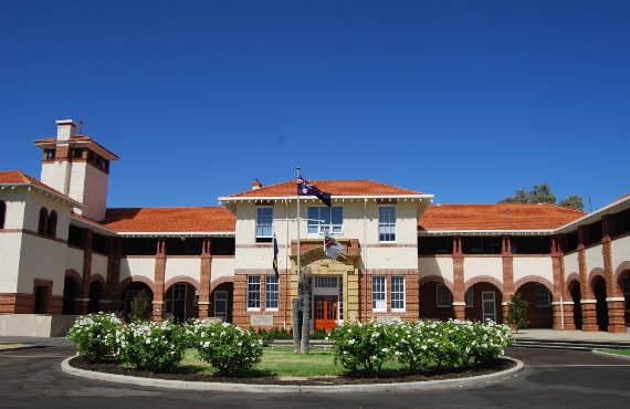 two story building with a round garden in front of it