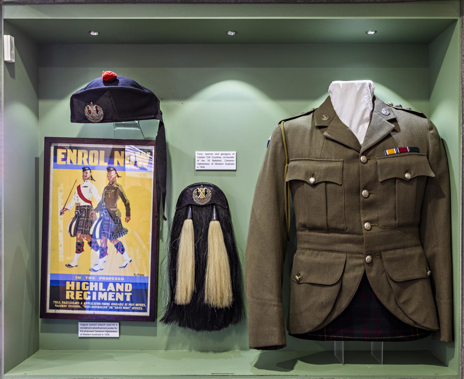 "Display case showcasing a military uniform and accessories from a Highland Regiment. Includes a khaki green jacket adorned with medals, a feathered sporran, a traditional bonnet with insignia, and a vintage recruitment poster encouraging enlistment in the Highland Regiment."