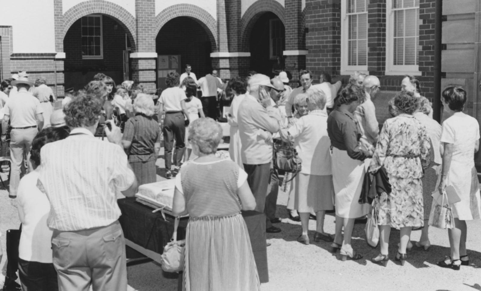 Crowd surrounding Birthday Cake