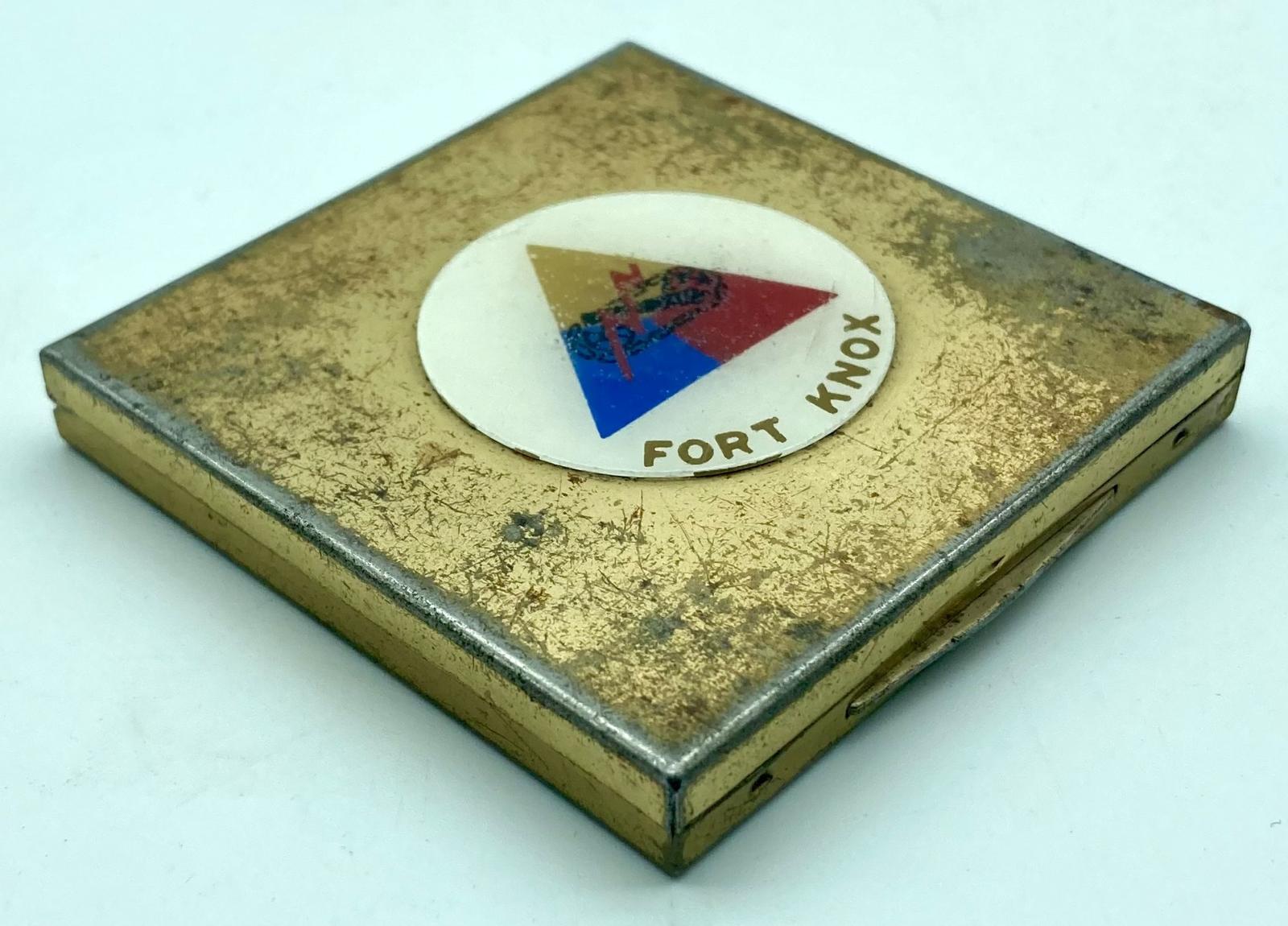 Gold-toned powder compact with Fort Knox logo - oblique front view