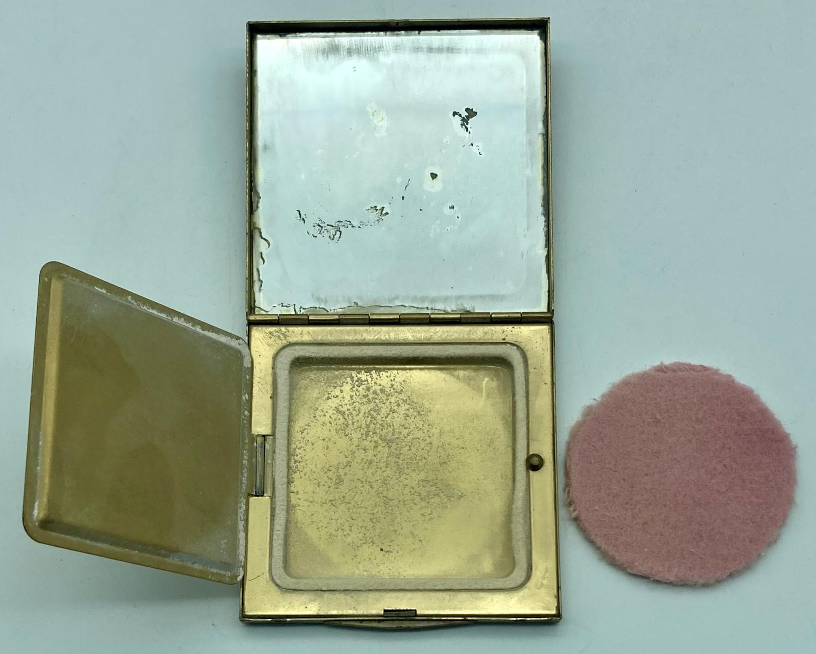 Open gold-toned powder compact with Fort Knox logo showing powder puff