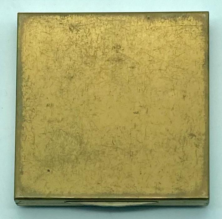 Back of gold-toned powder compact with Fort Knox logo