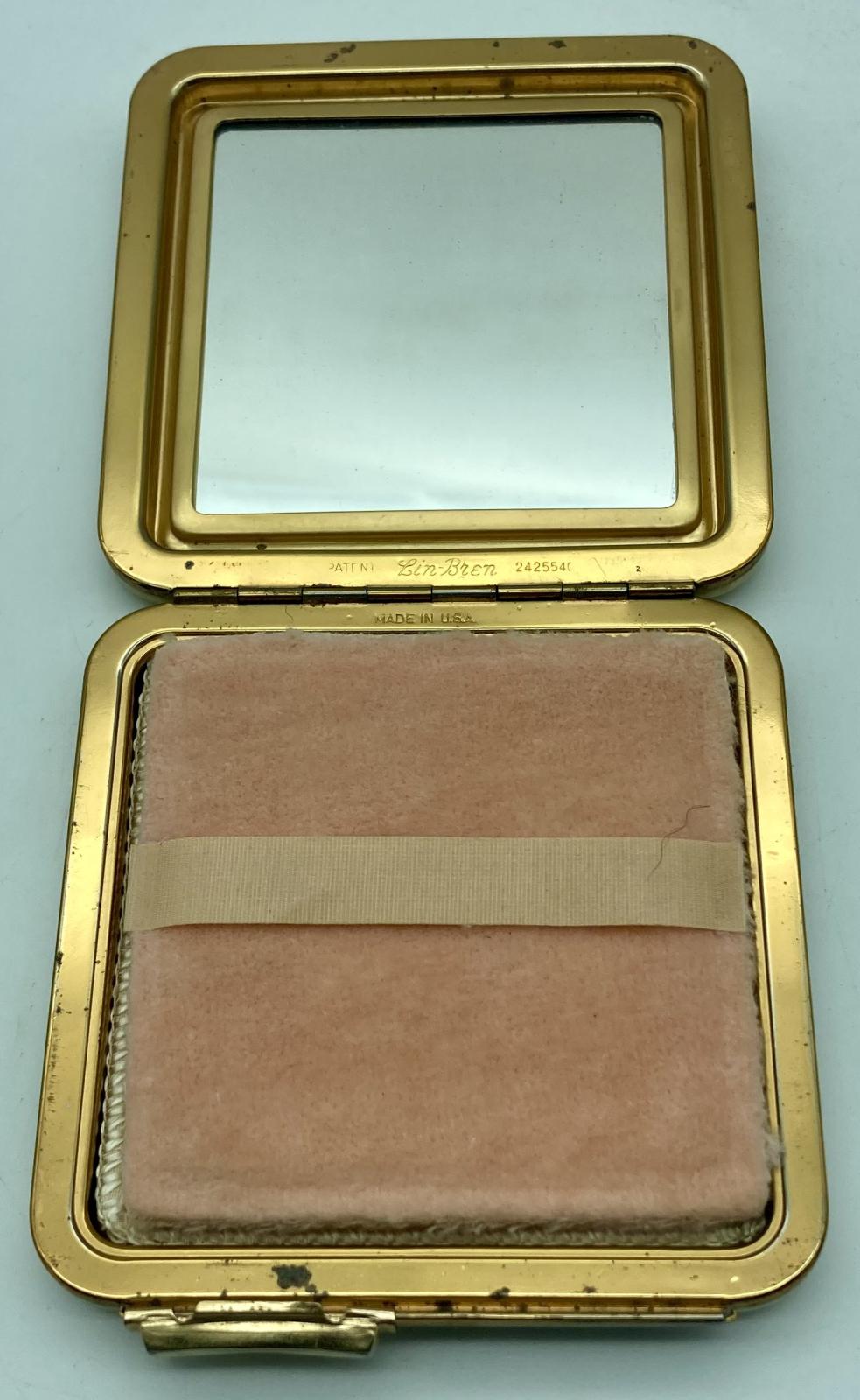 Open mother of pearl powder compact with enamel badge