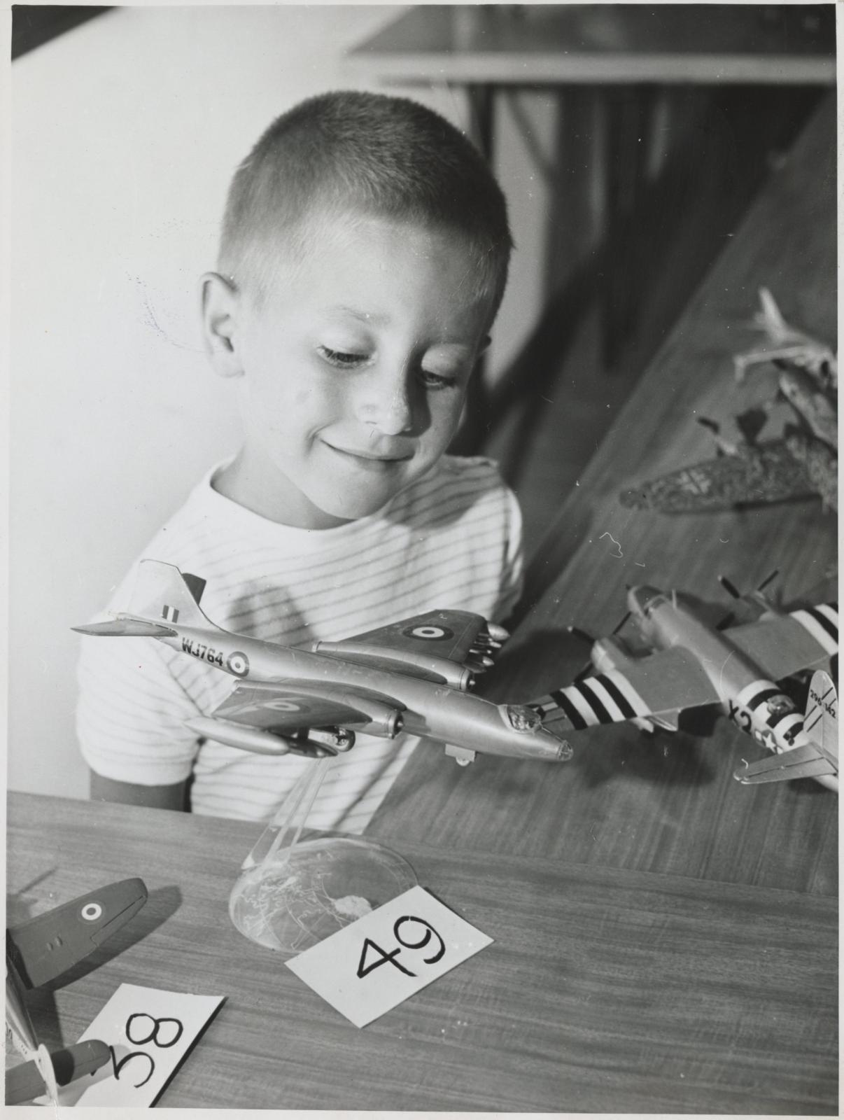 Boy admiring model planes.