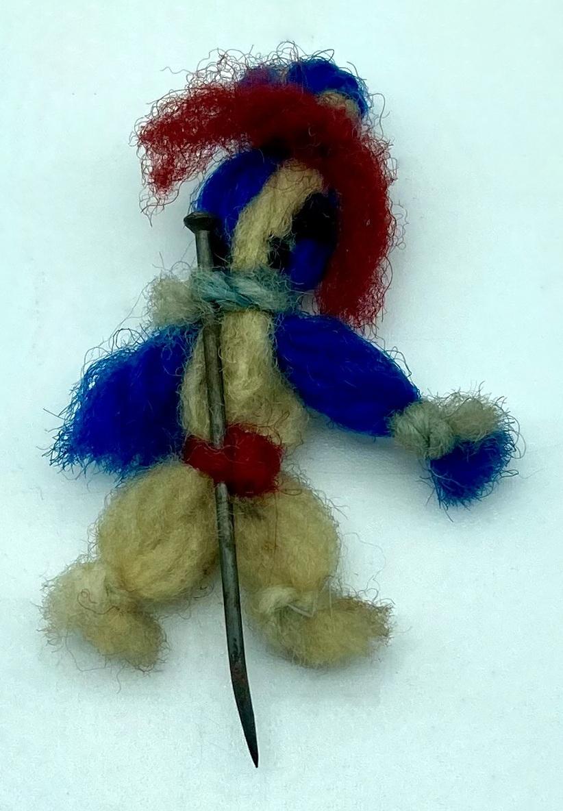 Reverse of WWI era patriotic fundraising pin in the form of a miniature woollen doll