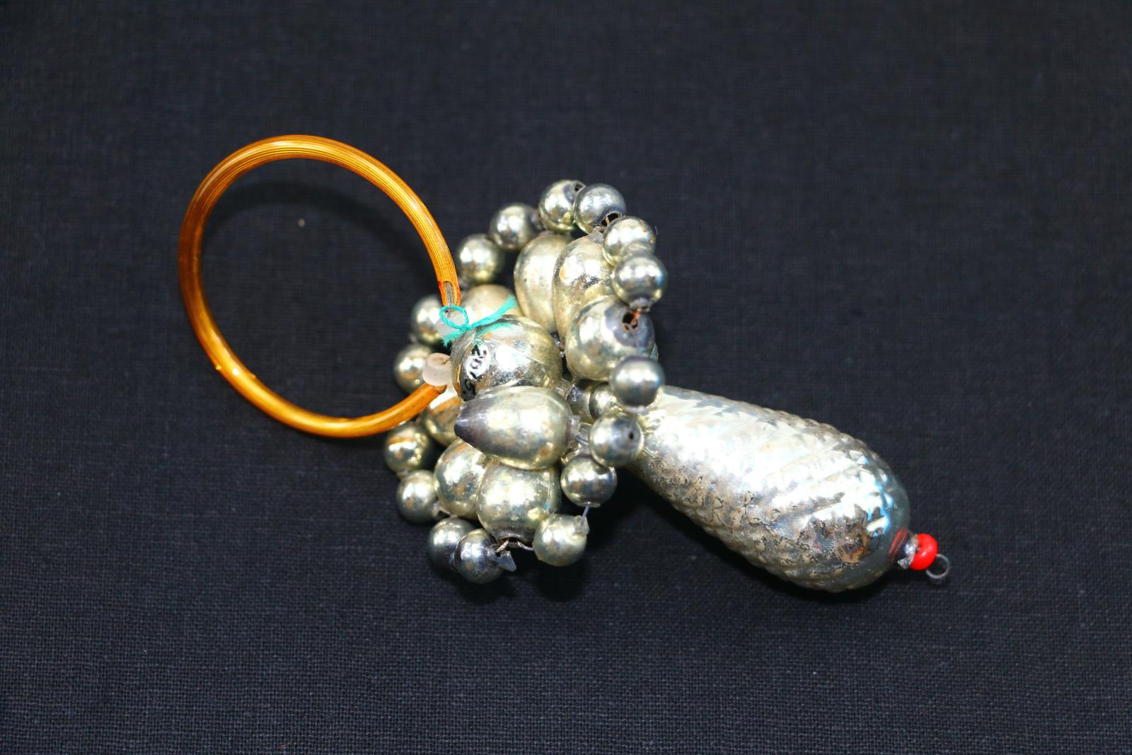 Round, silver, plastic, beaded, baby's dummy shaped Christmas decoration. 