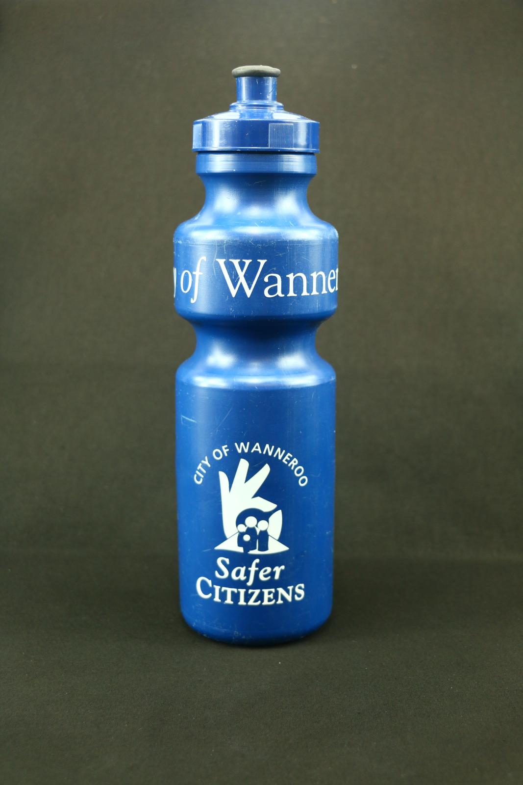 Tall, cylindrical, navy blue plastic drink bottle. Detachable screw-on lid with black, soft plastic, push-down sipper. 