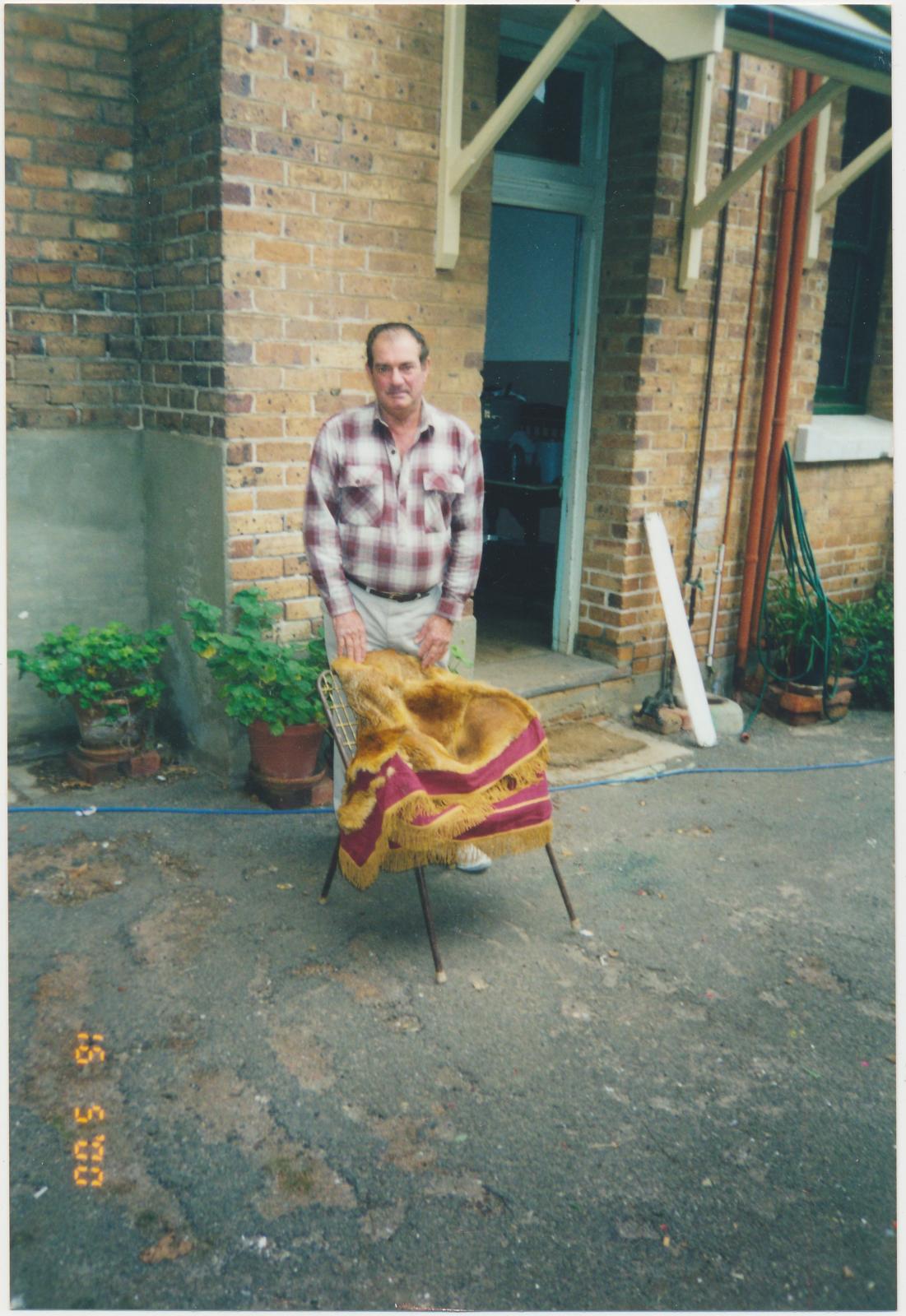 Man standing behind a chair with the Fox Skin Rug on it.