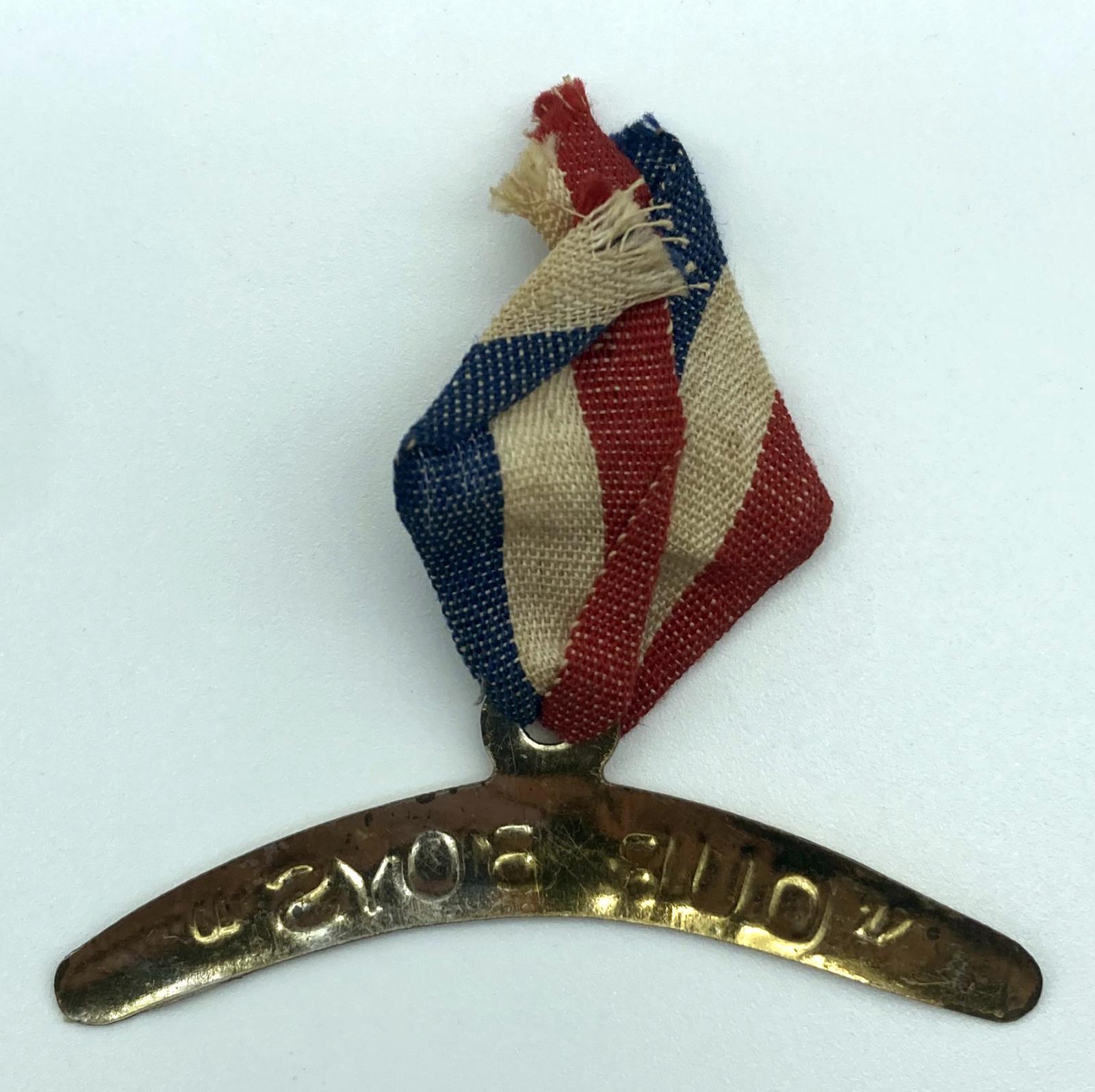 Reverse of second WWI fundraising metal boomerang on a tricolour ribbon supporting 'Our Boys'