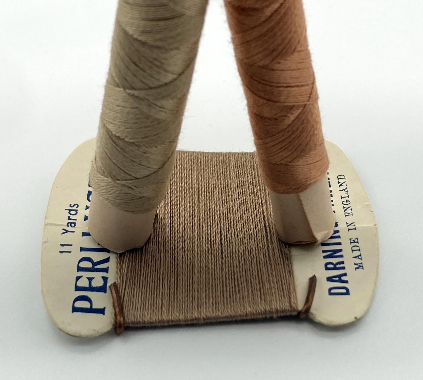 Close up of base of WWII 'Make Do and Mend' pantyhose repair kit in form of doll