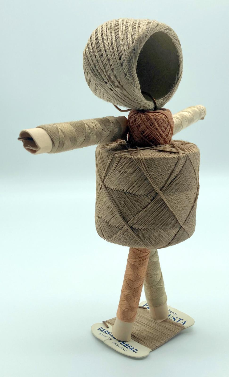 Reverse oblique view of WWII 'Make Do and Mend' pantyhose repair kit in form of doll