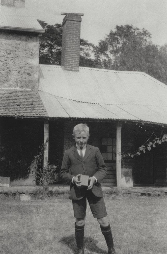 Lad With Camera At Rear Of House