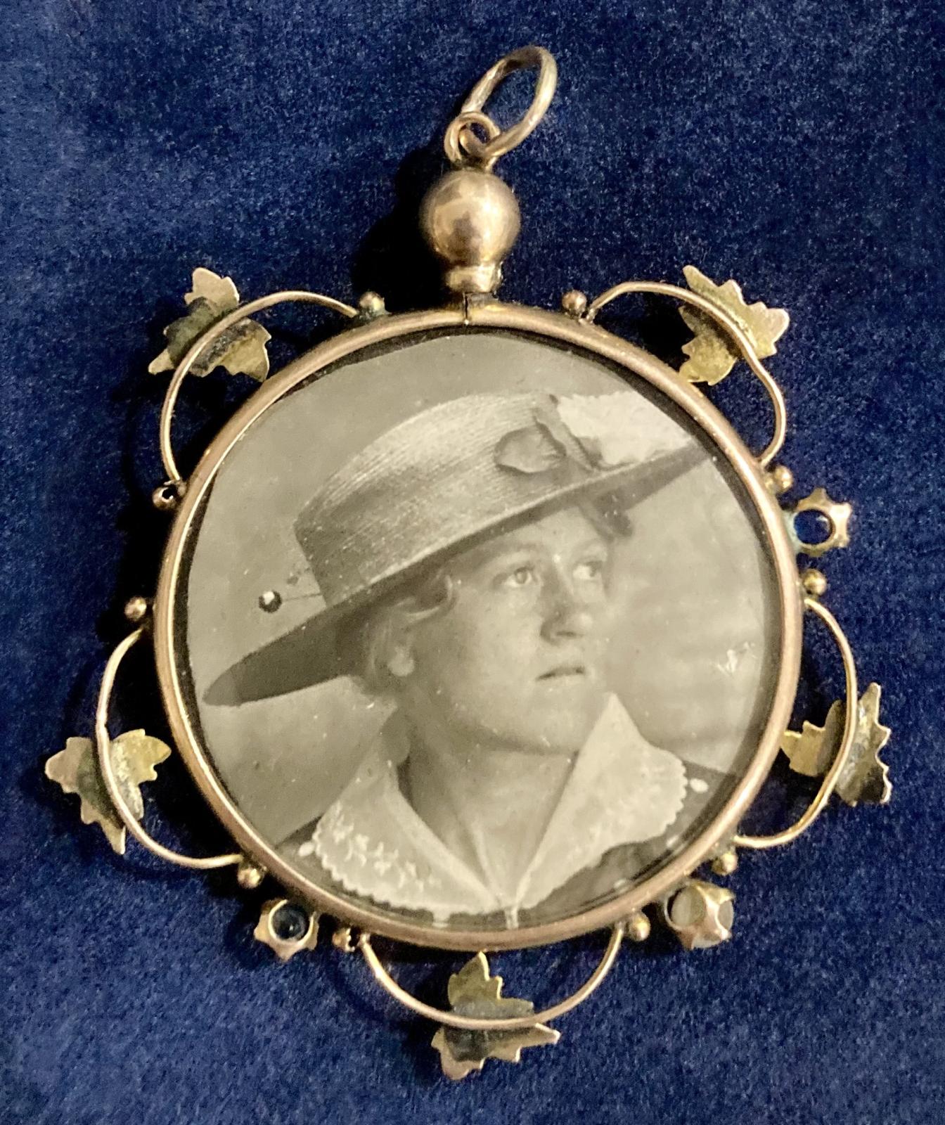 WWI era decorative double-sided pendant locket showing young woman wearing hat