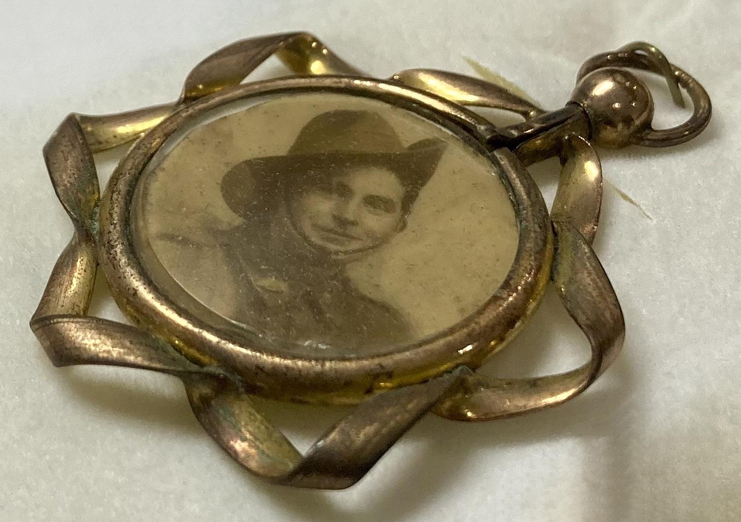 Side view of WWI era double-sided pendant locket featuring soldier
