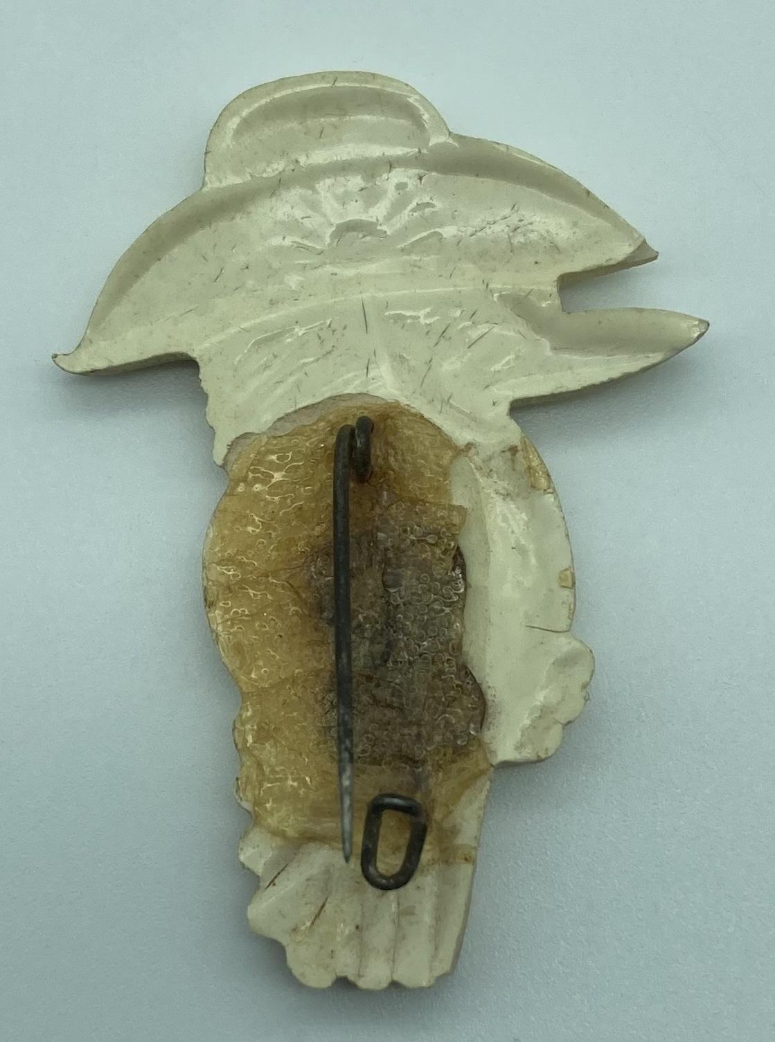 Reverse of moulded plastic brooch depicting a kookaburra wearing a slouch hat