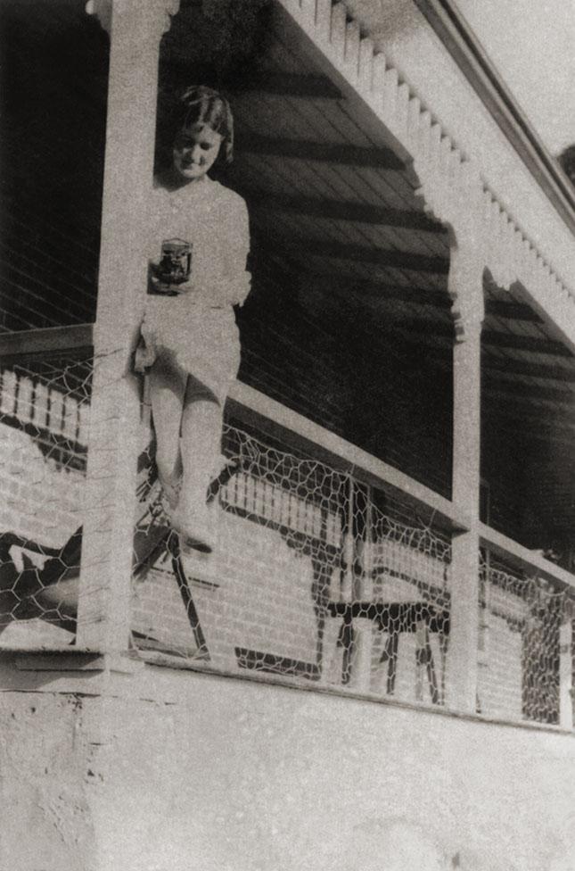 Young Woman With Camera On A Verandah