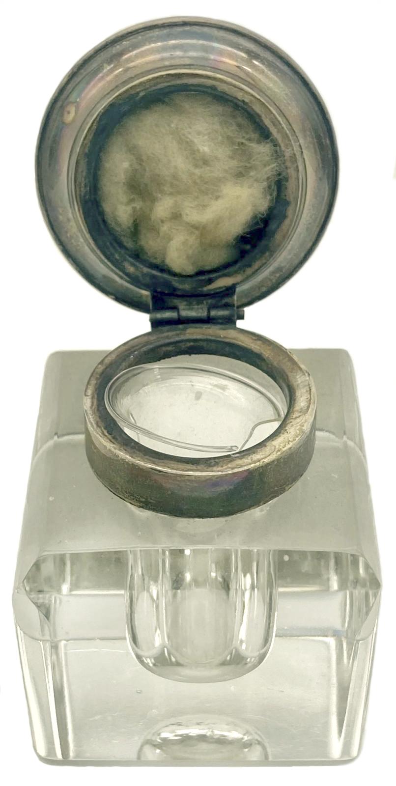 Side view of crystal glass inkwell with lid up, showing inside