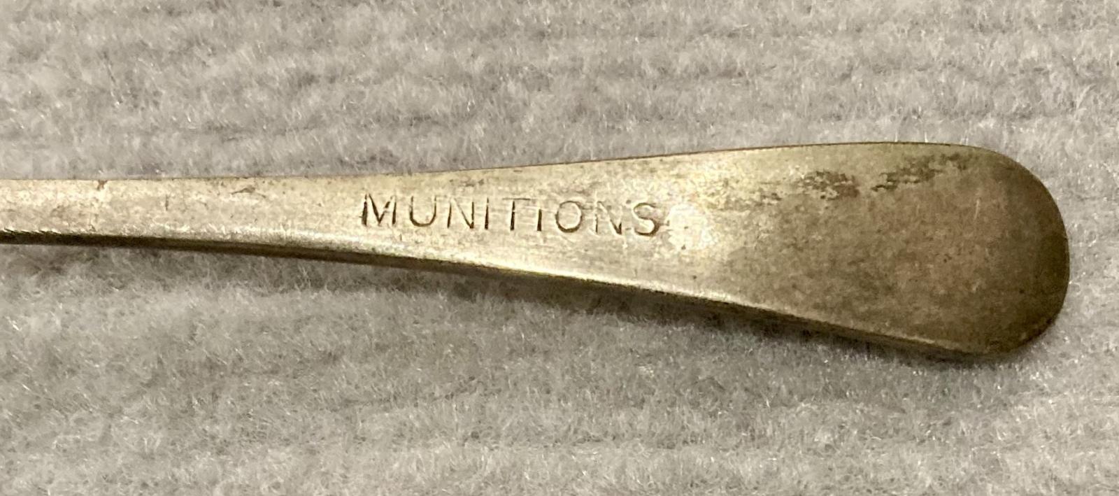 Close up of Allbrite nickel silver spoon stamped with 'Munitions'