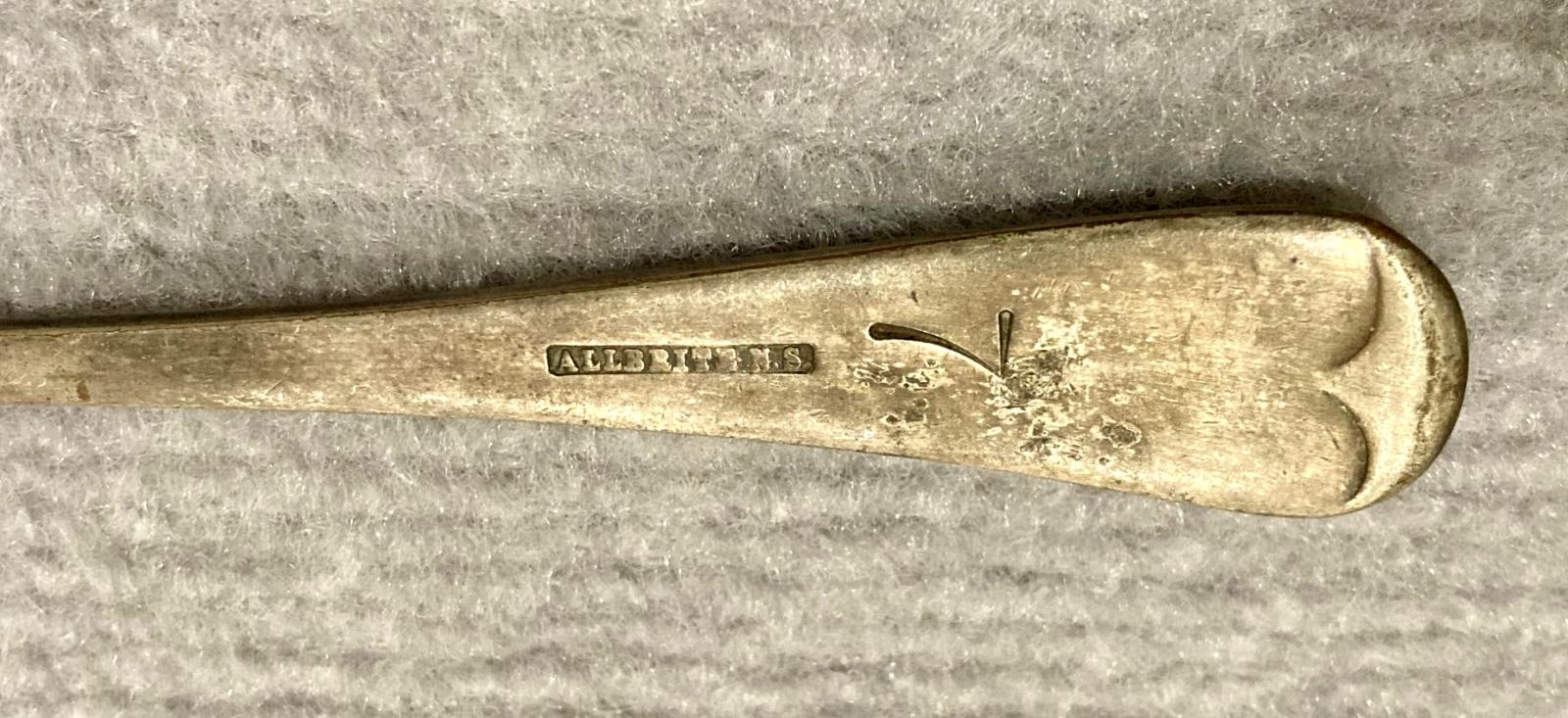 Close up of reverse of Allbrite nickel silver spoon stamped with 'Munitions'