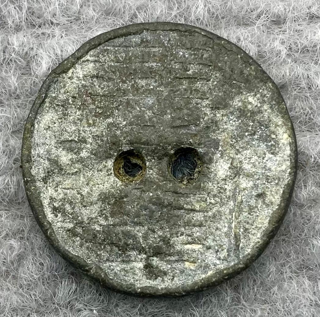 Front of lead button from clothing worn by munitions worker