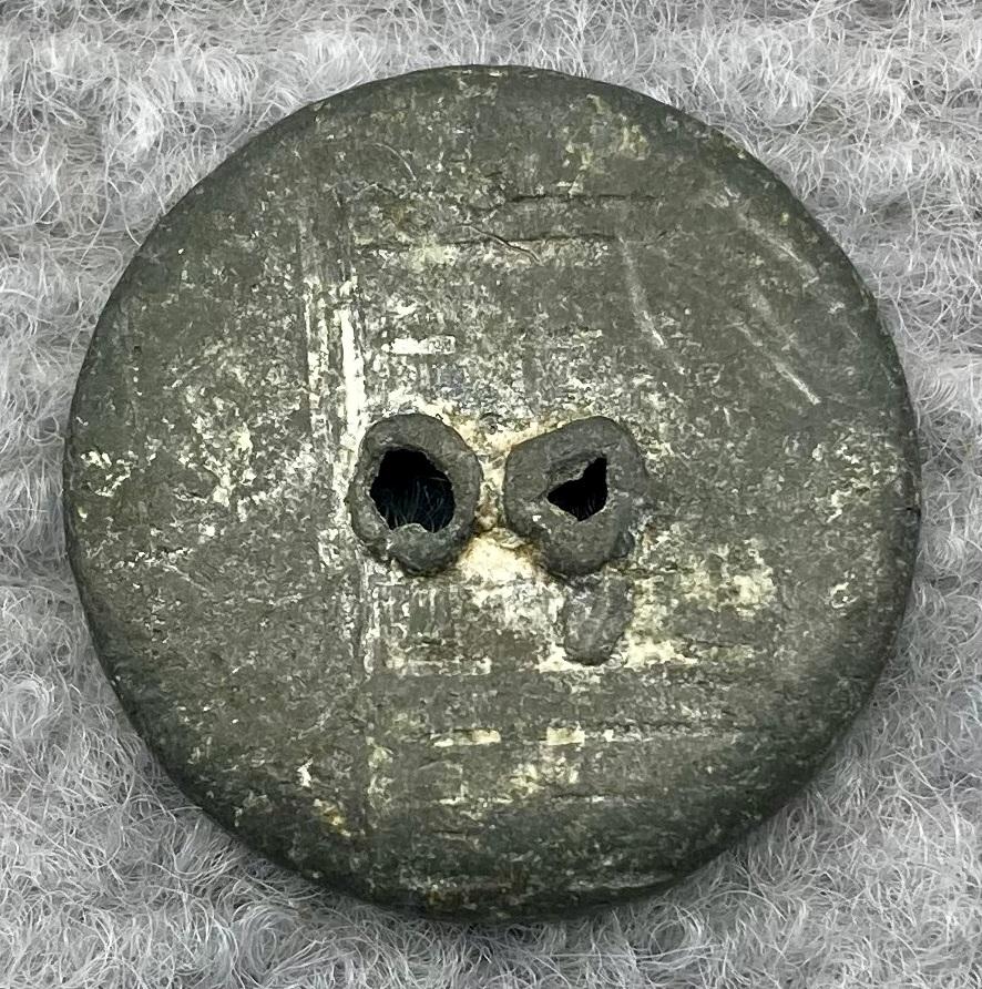 Reverse of lead button from clothing worn by munitions worker