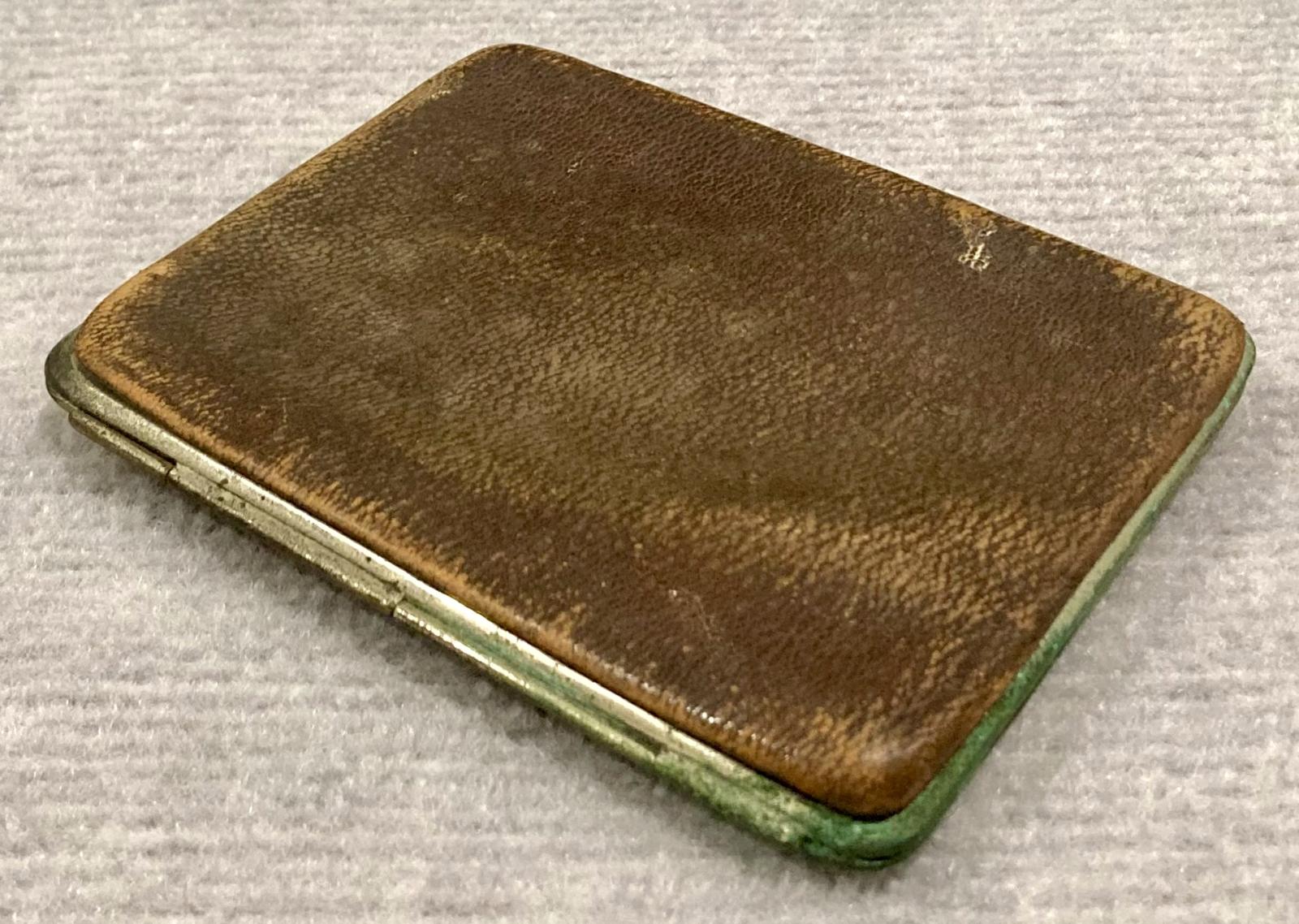 Oblique view of metal-edged leather wallet showing hinge
