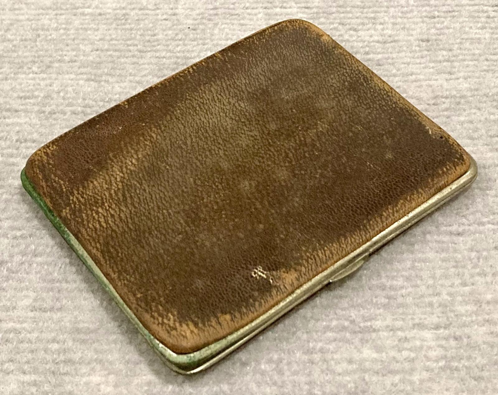 Oblique view of metal-edged leather wallet showing clasp