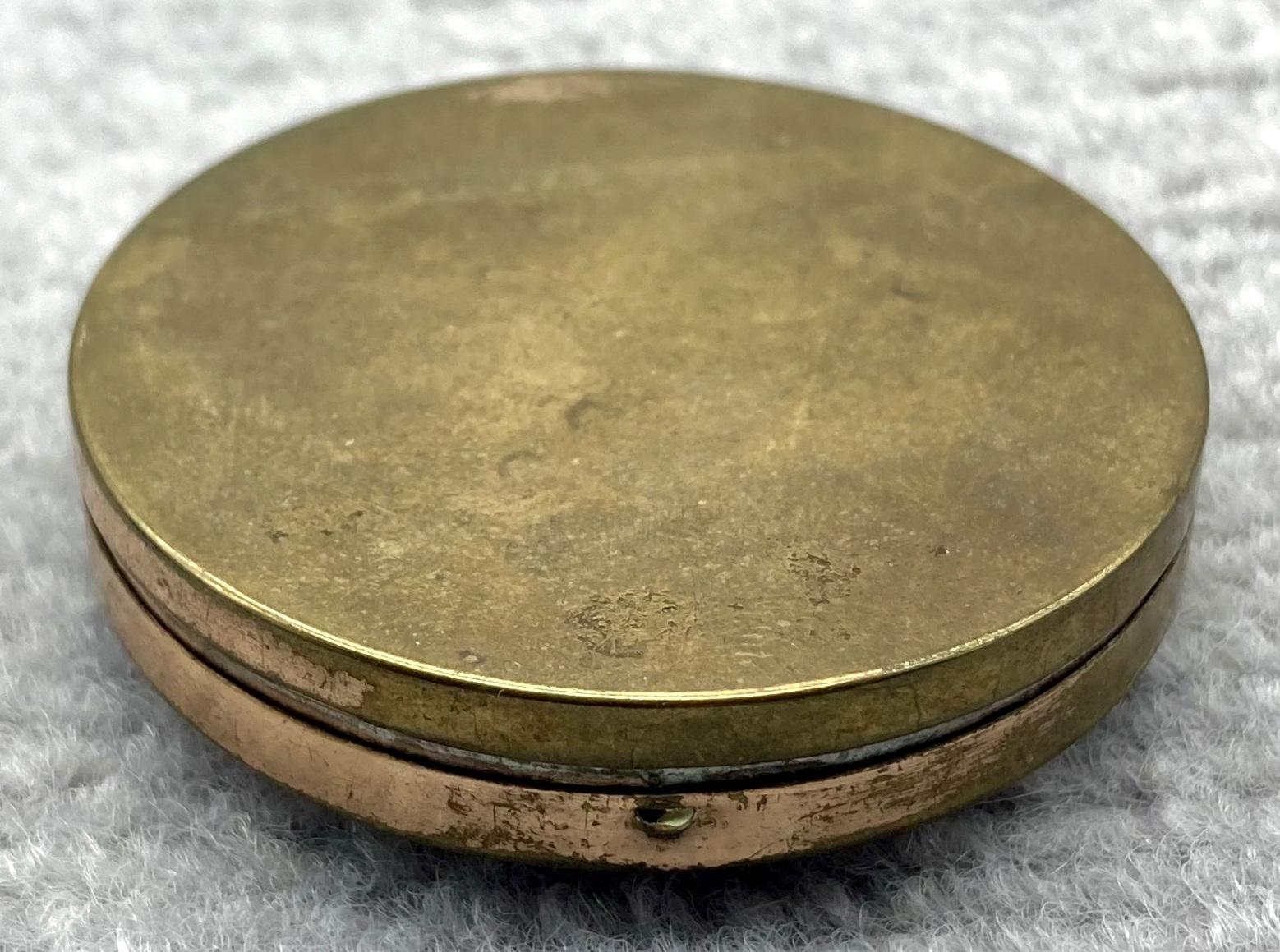 Oblique view of underside of souvenir powder compact from Palestine