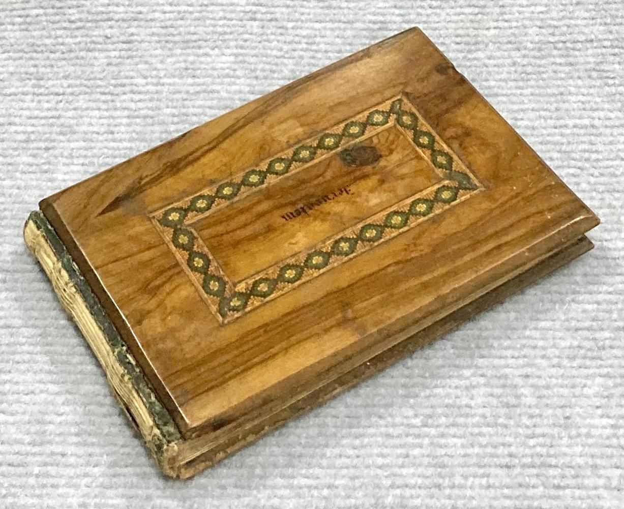 Oblique view of front of souvenir olive wood album 