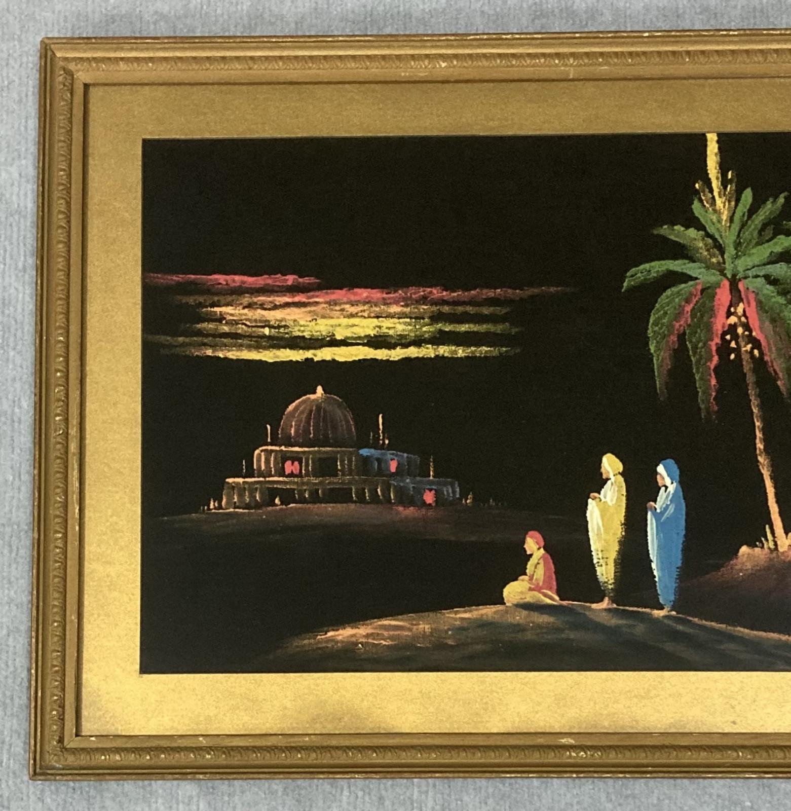 Close up of left hand side of framed painting on black velvet of Middle Eastern scene