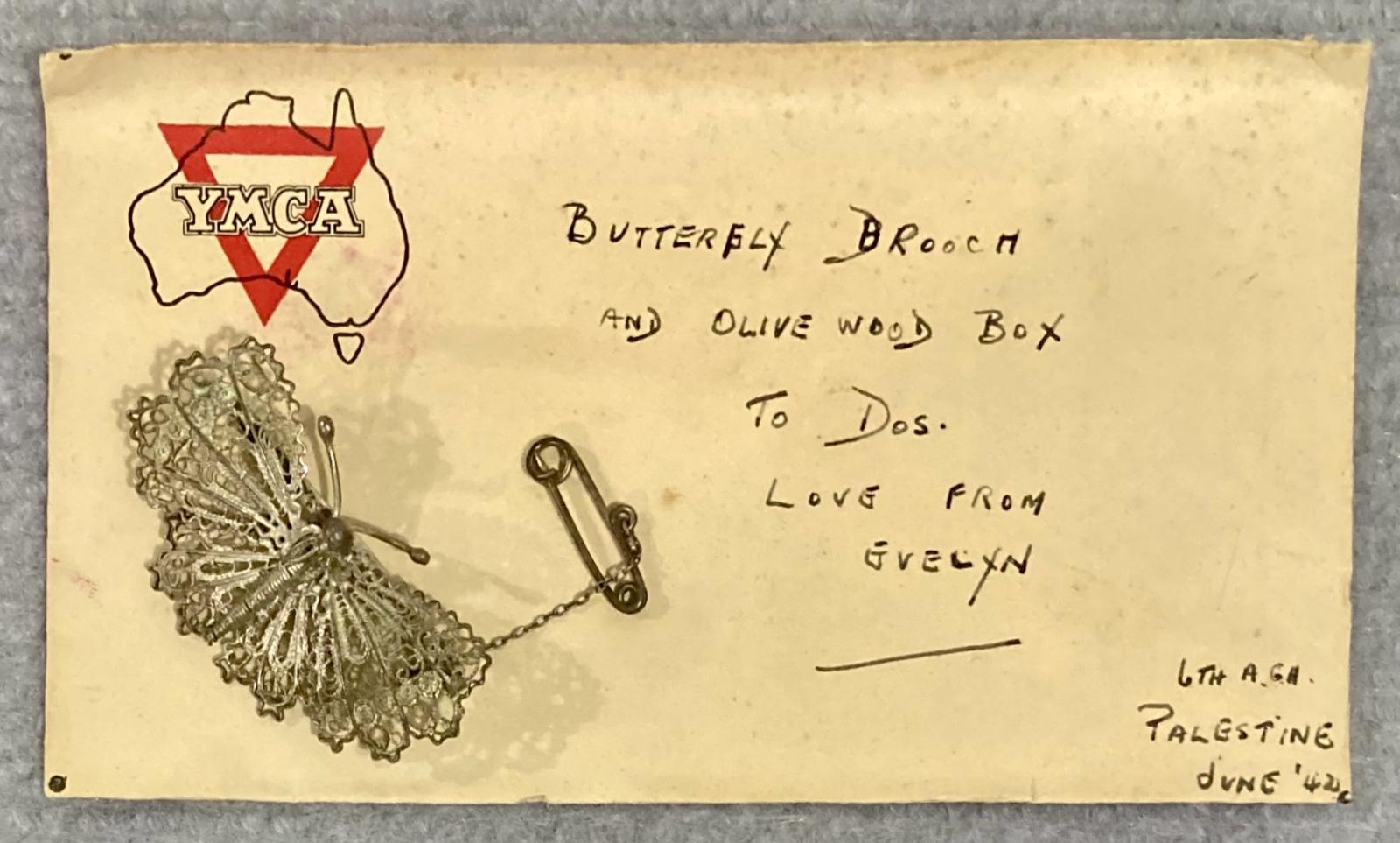 Silver filagree butterfly brooch on Y.M.C.A. envelope