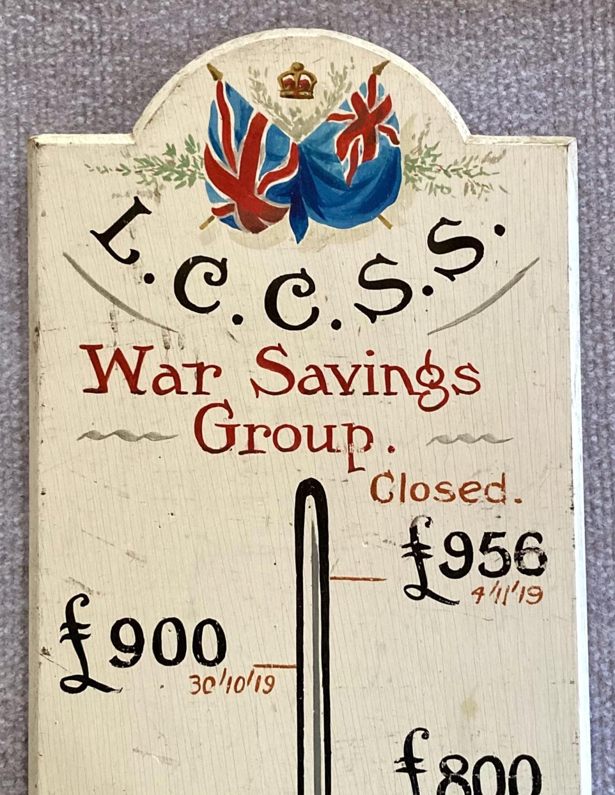 Close up of top section of painted timber War Savings Group plaque