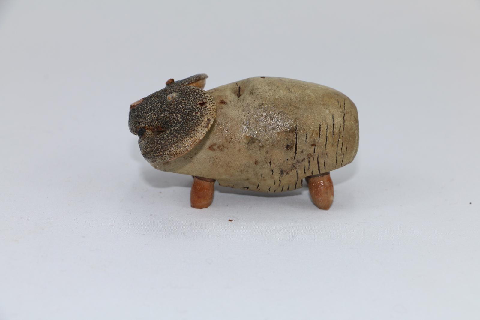  A gumnut figure in shape and style of a 'ram' is fashioned by a large unidentified eucalypt split nut with seed pods attached denoting legs and a hakea nut split in half attached at top of nut depicting ram's horns.
