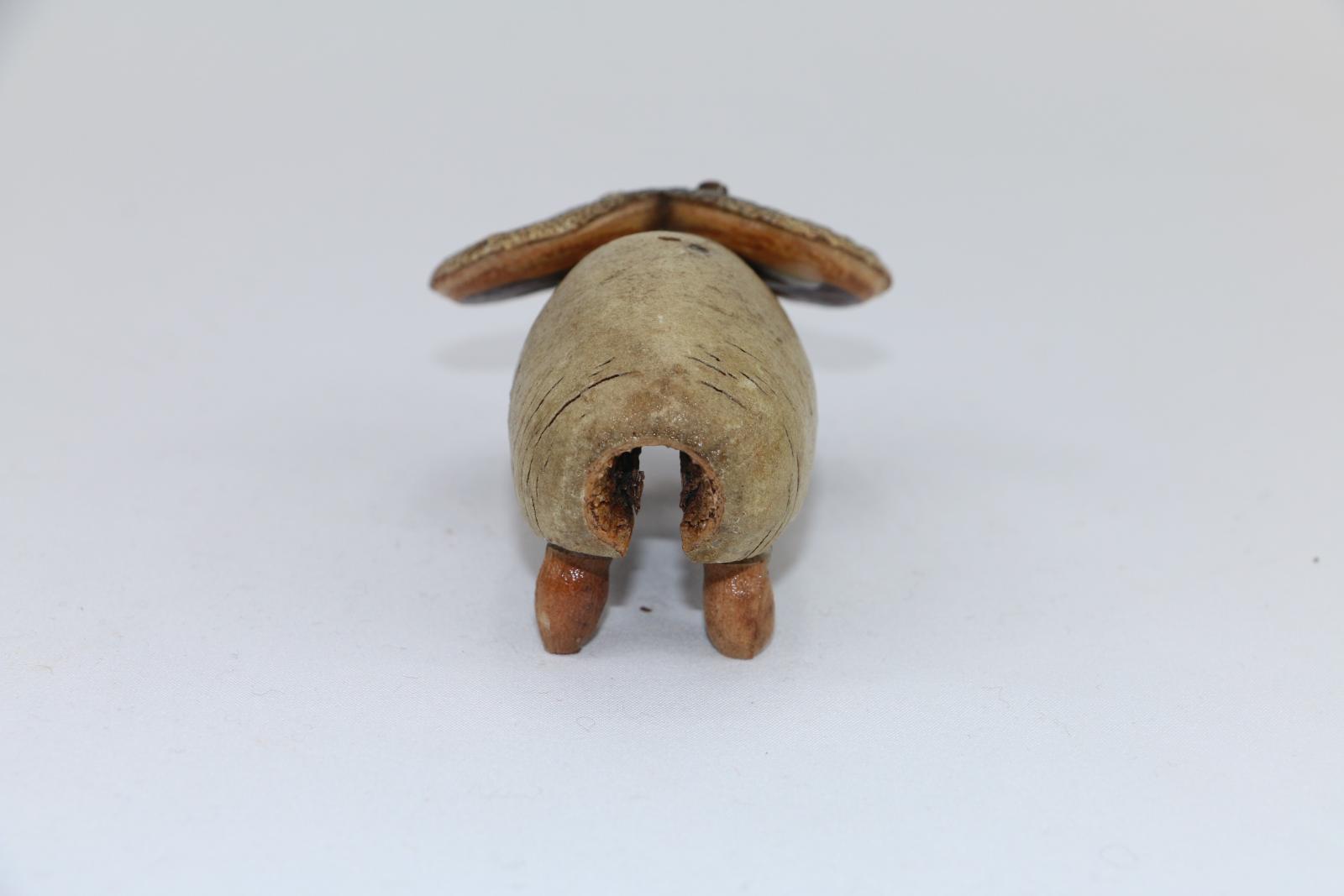  A gumnut figure in shape and style of a 'ram' is fashioned by a large unidentified eucalypt split nut with seed pods attached denoting legs and a hakea nut split in half attached at top of nut depicting ram's horns.