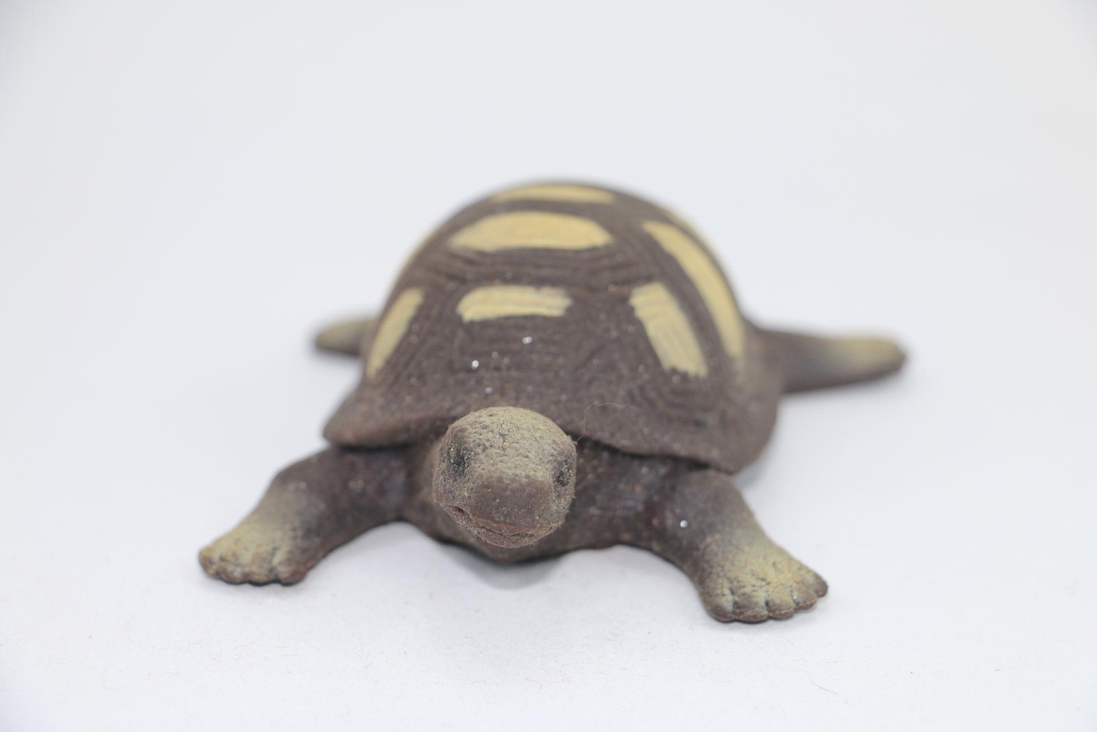 Silicone toy turtle, brown with lighter brown decorations along the shell.