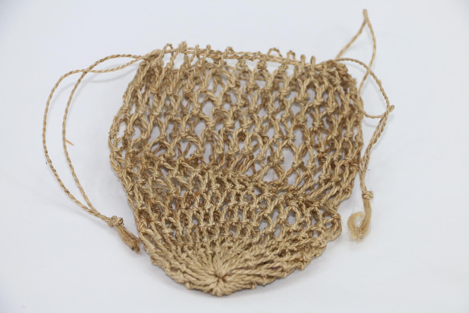 Light brown/ cream coloured woven bag that can be tied closed at the top with two drawstrings.