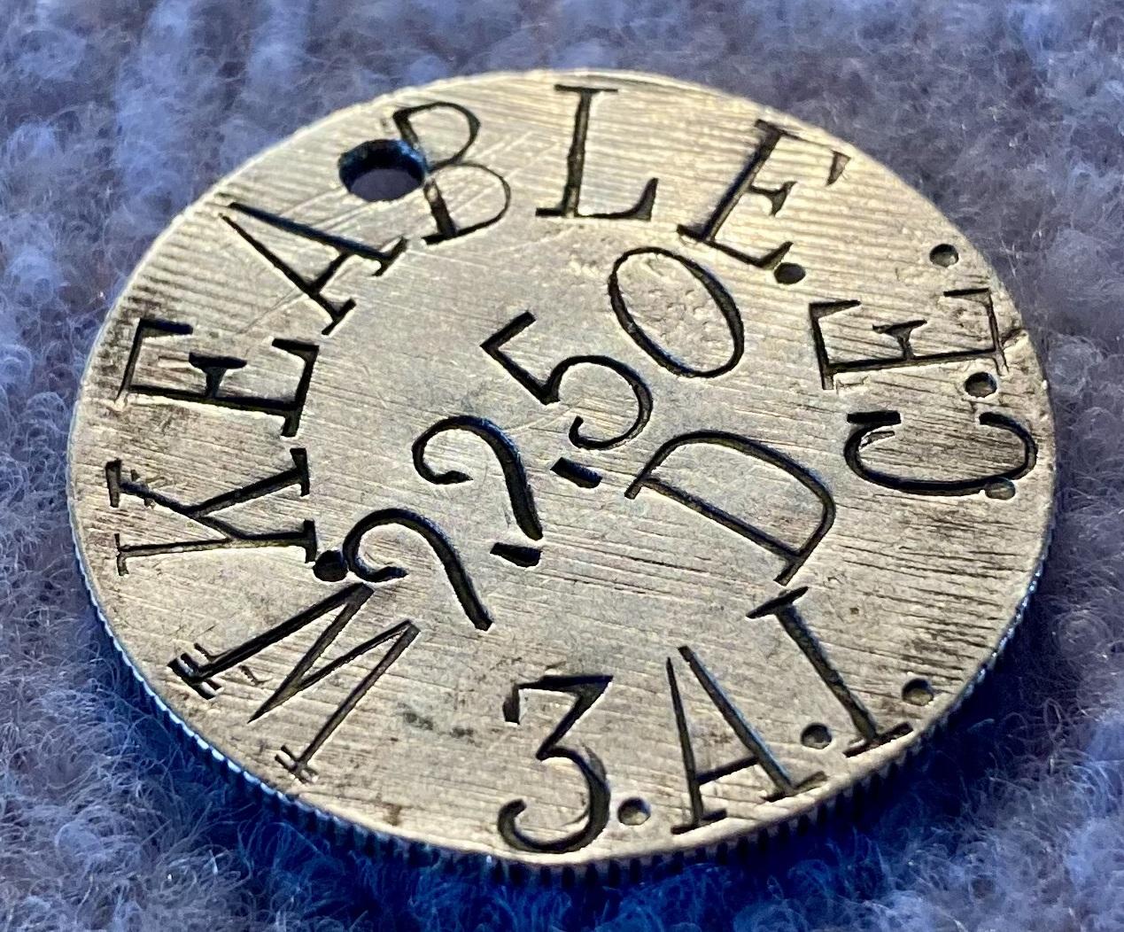 Oblique view of WWI identity disc made from a coin for Private William Keable