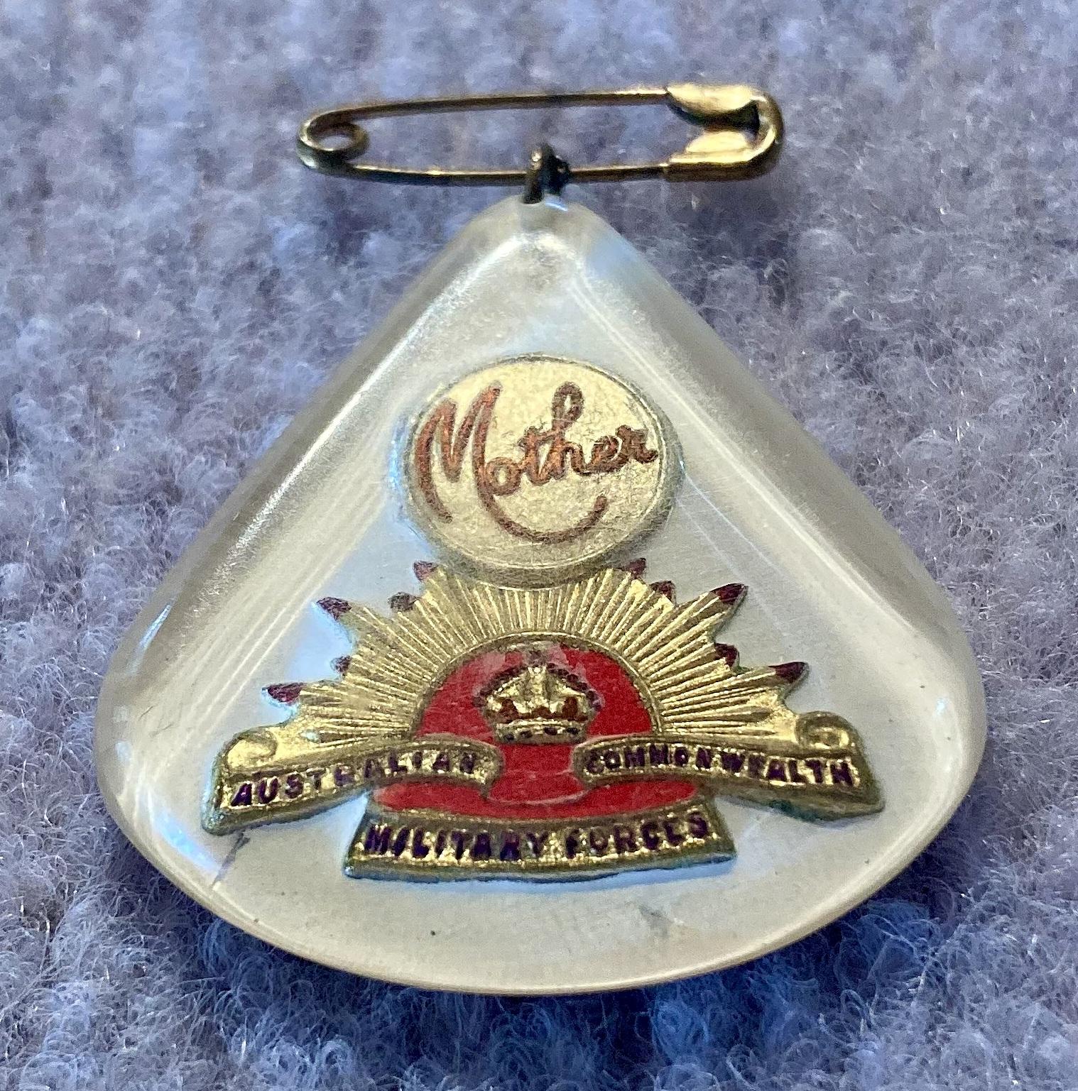 Oblique view of Perspex sweetheart brooch depicting rising sun badge - red