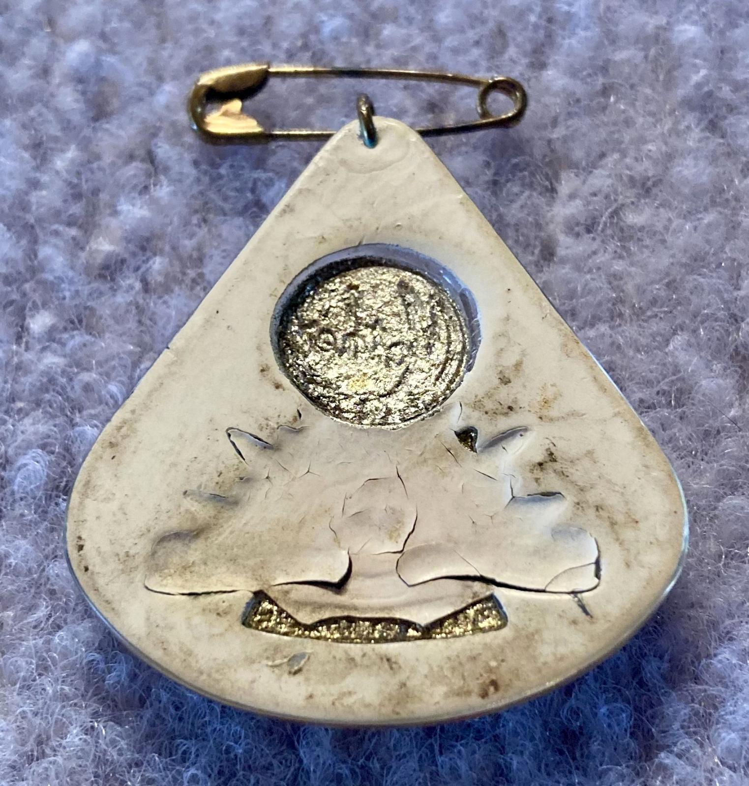 Oblique view of reverse of Perspex sweetheart brooch depicting rising sun badge - red