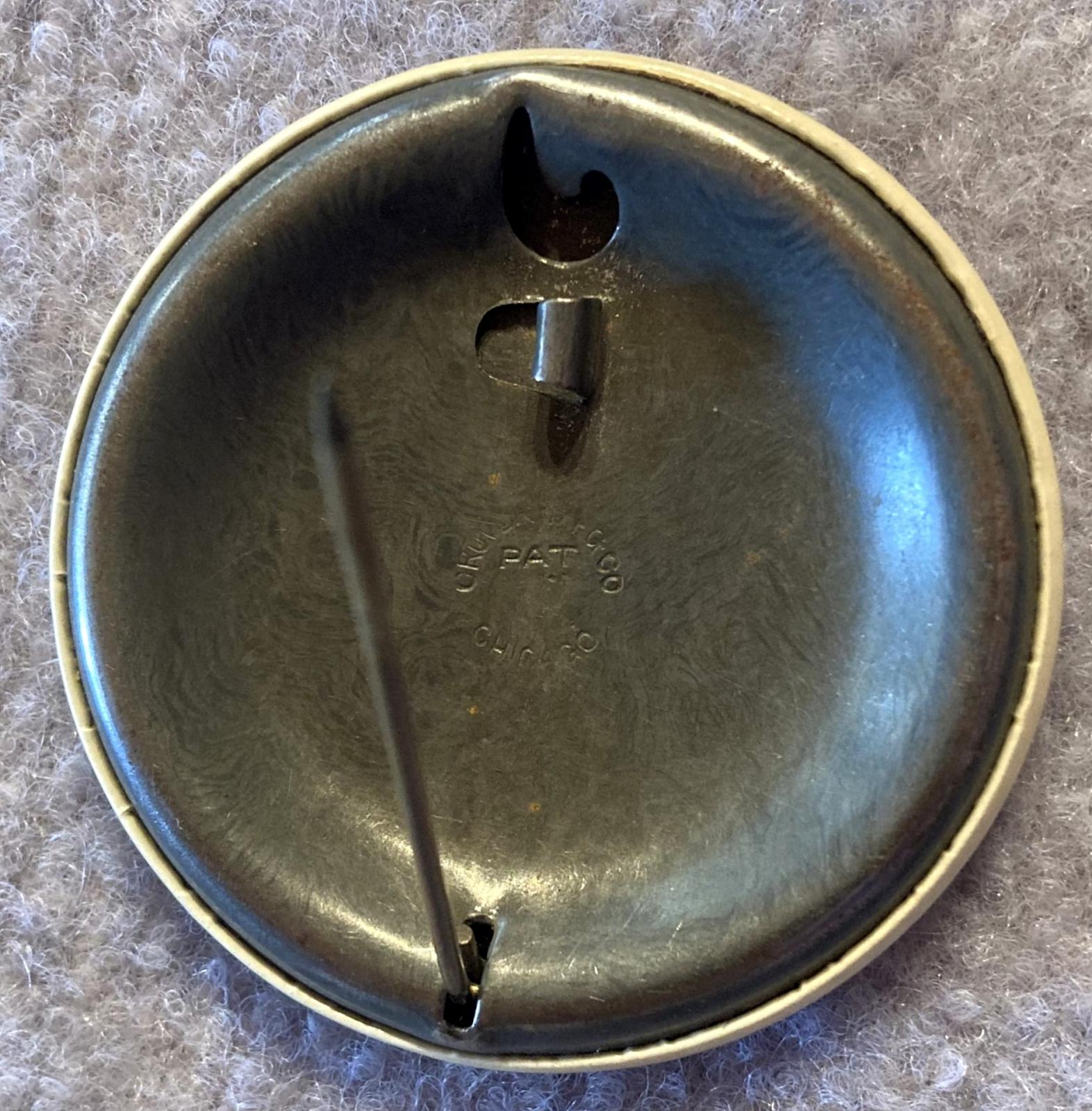 Reverse of Cheer-Up Society Warden's badge showing maker's mark