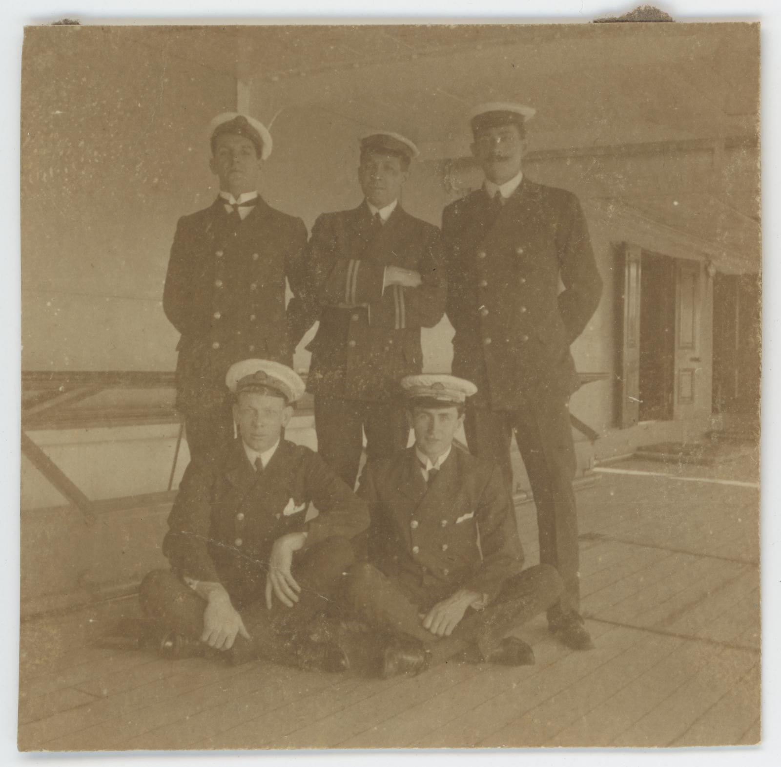 Photo of Raymond WARBURTON (seated right) with 4 unidentified crew members