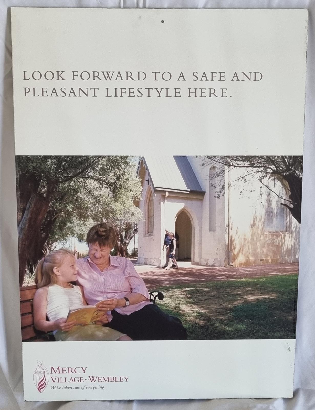 25-213.1 Mercy village Wembley poster front-side image with background.
