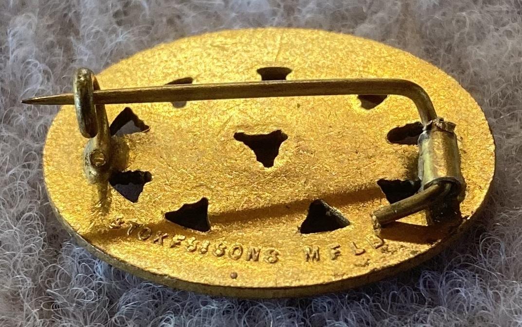 Angled view of reverse of 'Wattle Day 1918' metal and enamel fundraising brooch