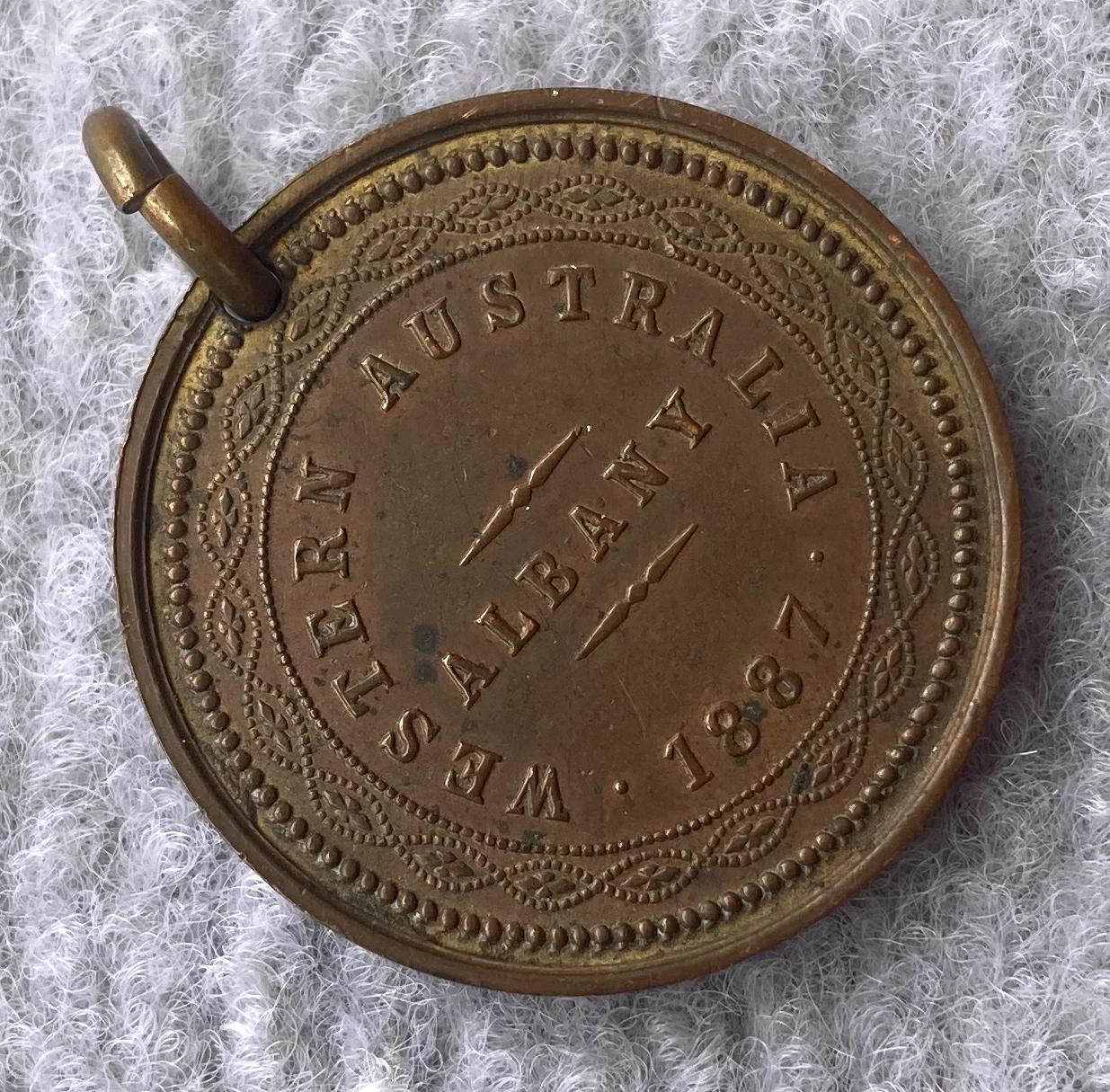 Oblique view of one side of a medallion issued in Albany in 1877