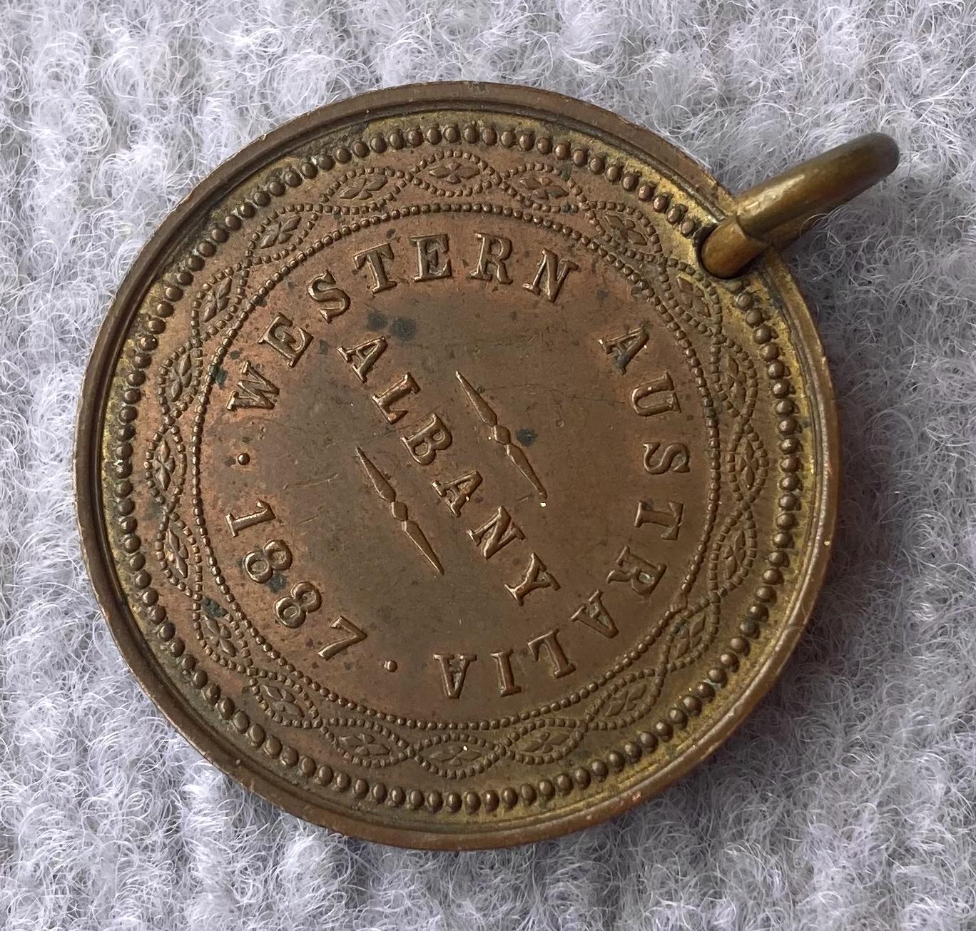 Oblique view of one side of a medallion issued in Albany in 1877