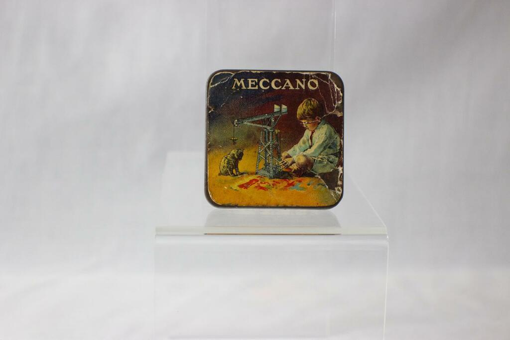 An original Meccano tin from circa 1930, containing an assortment of miniature screws, washers, and fasteners used in early Meccano construction sets.